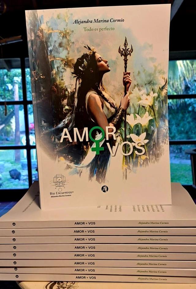 Ejemplares del libro Amor+Vos, de Alejandra Marina Cormio, apilados junto a una ventana