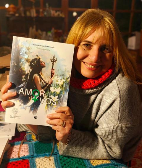 Alejandra Marina Cormio sonriendo con el libro Amor+Vos